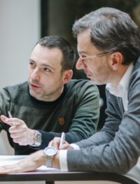 2 Männer am Tisch. Besprechung