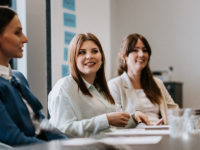 3 women sitting at a conference table.