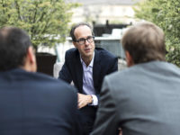 Man talking to 2 men.
