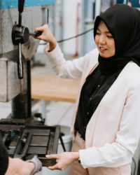 Woman operating a machine in a factory.