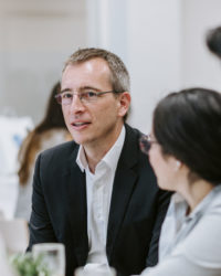 Man in a suit sitting at a table.