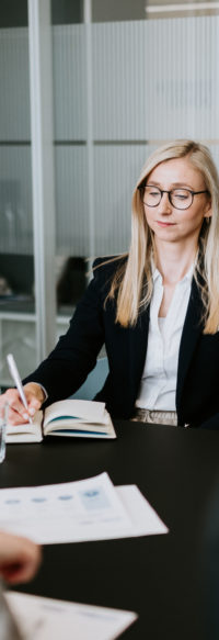 Woman sitting at a conference table.