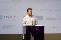man speaking on a stage to people
