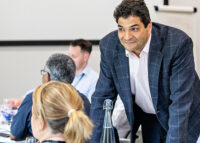 man in suit leaning over table